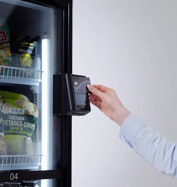 Resident paying with a contactless card on a cashless smart cooler vending machine in a North DFW apartment
